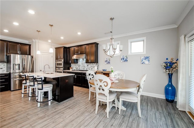 kitchen featuring appliances with stainless steel finishes, backsplash, hanging light fixtures, and sink