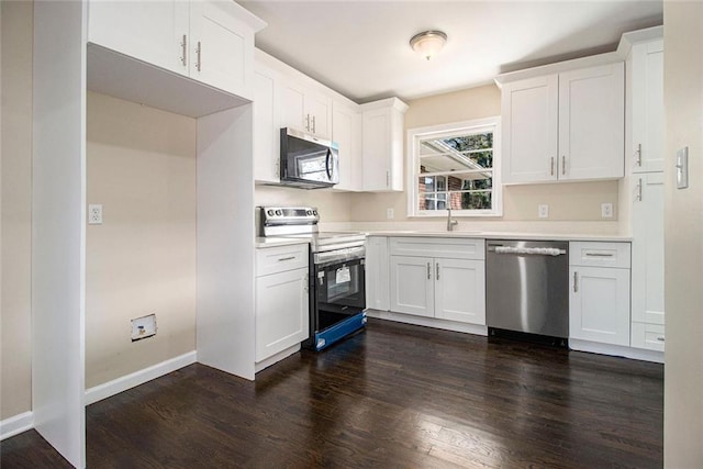 1207 Ellington Dr, Morrow, GA 30260 - kitchen featuring stainless steel appliances, white cabinets, dark wood finished floors, light countertops, and a sink