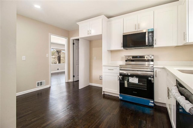 1207 Ellington Dr, Morrow, GA 30260 - kitchen with stainless steel appliances, dark wood-style flooring, white cabinets, light countertops, and recessed lighting