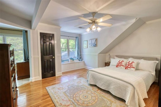 bedroom featuring wood finished floors, ornamental molding, ceiling fan, and baseboards