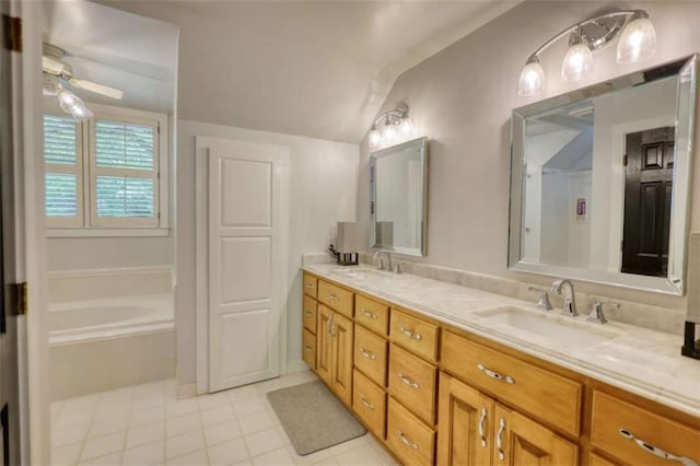full bath with tile patterned flooring, vaulted ceiling, double vanity, tiled tub, and a ceiling fan