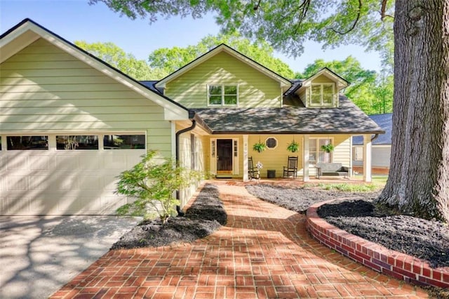 view of front of home with a garage, a porch, and driveway