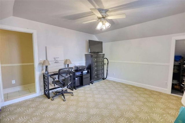 carpeted home office featuring ceiling fan, vaulted ceiling, and baseboards