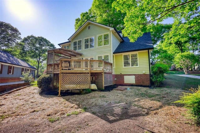 back of house with a wooden deck, a pergola, and roof with shingles