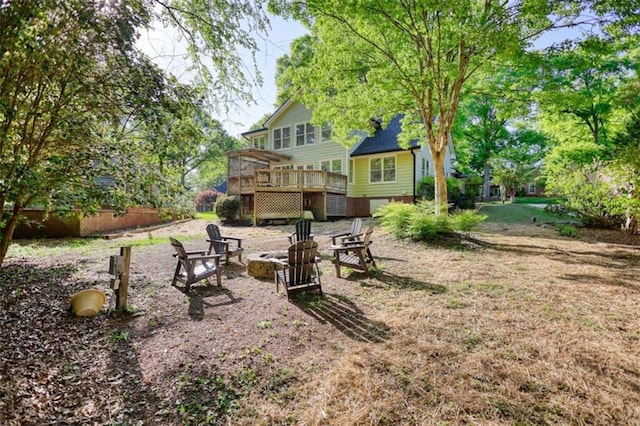 view of yard featuring a wooden deck and an outdoor fire pit