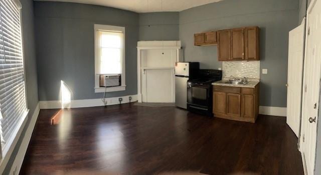 kitchen with black range oven, cooling unit, sink, decorative backsplash, and dark hardwood / wood-style flooring