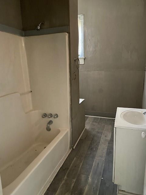 bathroom with hardwood / wood-style floors, vanity, and  shower combination