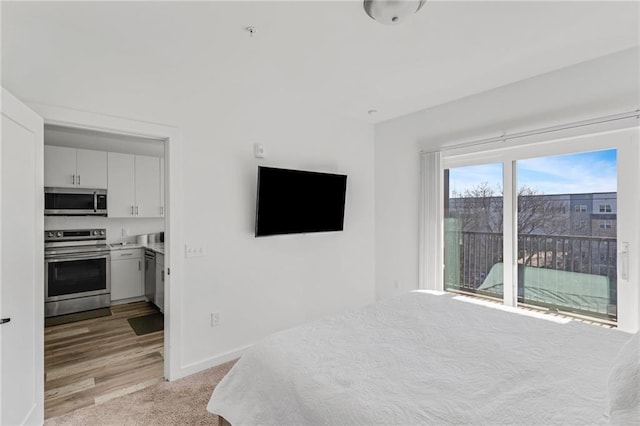 bedroom with light carpet and access to outside