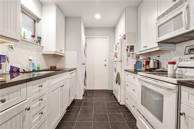 1111 Clairemont Ave Unit N5, Decatur, GA 30030 - kitchen featuring backsplash, dark countertops, dark tile patterned flooring, white appliances, and white cabinetry