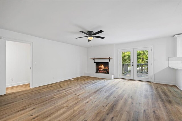 unfurnished living room with hardwood / wood-style flooring, french doors, and ceiling fan