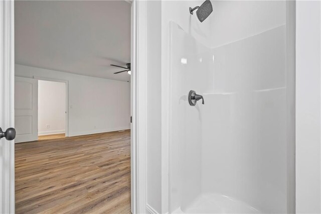 bathroom with ceiling fan, walk in shower, and hardwood / wood-style flooring