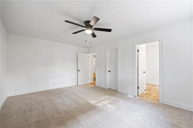 unfurnished bedroom featuring light carpet and ceiling fan