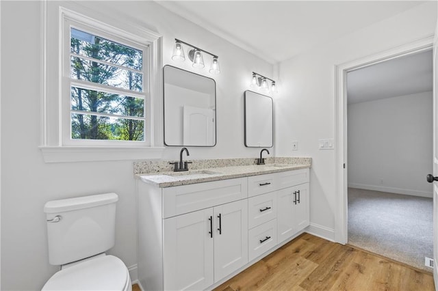 bathroom featuring hardwood / wood-style flooring, toilet, and double sink vanity