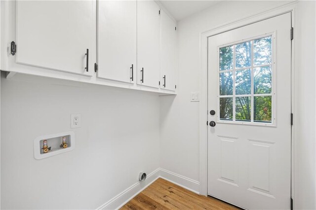 washroom with washer hookup, a healthy amount of sunlight, light hardwood / wood-style floors, and cabinets