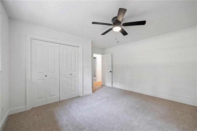 unfurnished bedroom with light carpet, ceiling fan, and a closet