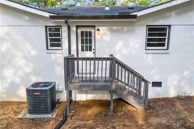 property entrance with a wooden deck and central air condition unit