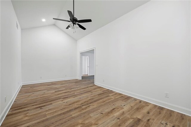 spare room with wood-type flooring, high vaulted ceiling, and ceiling fan