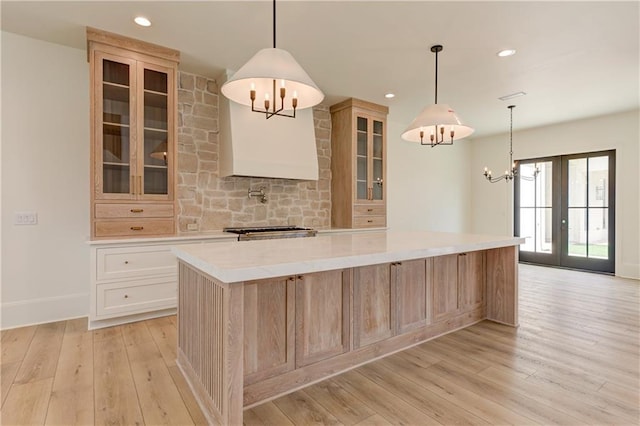 789 Old Mill Ct, Ball Ground, GA 30107 - kitchen featuring a chandelier, light wood finished floors, a large island, light countertops, and glass insert cabinets