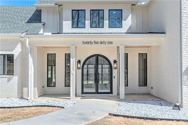 789 Old Mill Ct, Ball Ground, GA 30107 - doorway to property featuring brick siding, a porch, board and batten siding, and roof with shingles