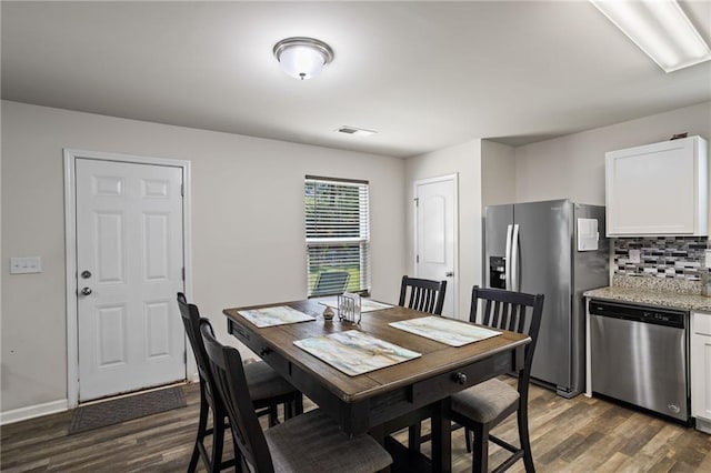 dining space with dark hardwood / wood-style flooring