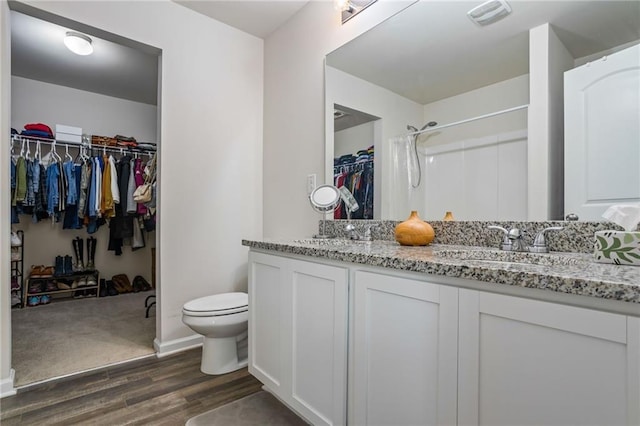 bathroom with vanity, wood-type flooring, walk in shower, and toilet