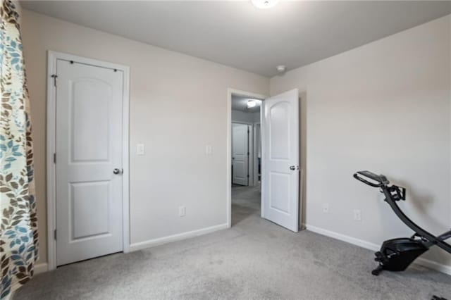 exercise room featuring light carpet