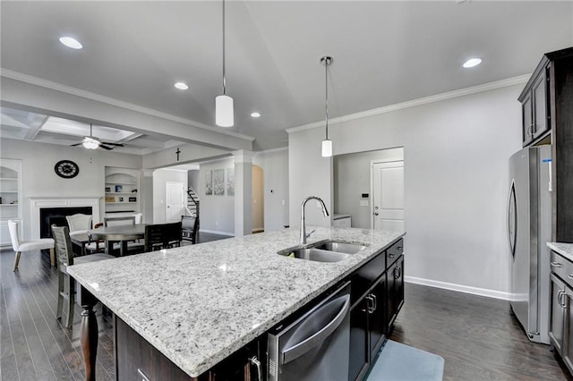 kitchen with a kitchen island with sink, coffered ceiling, sink, built in features, and beamed ceiling