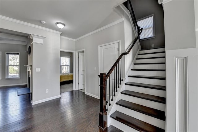 entrance foyer featuring dark hardwood / wood-style floors, a healthy amount of sunlight, and ornamental molding