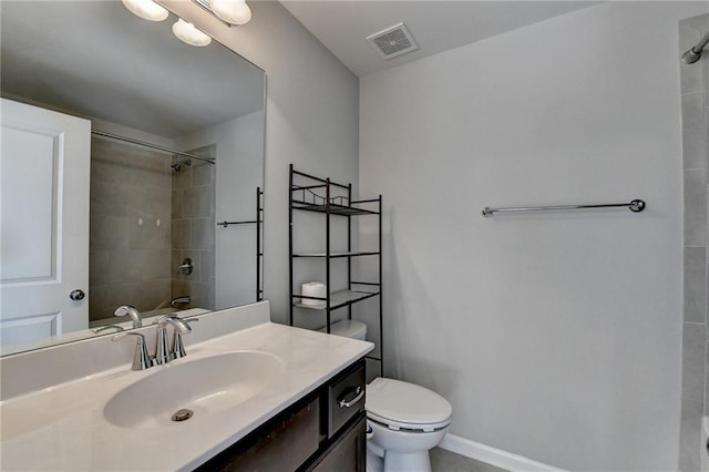 full bathroom with tile patterned flooring, vanity, tiled shower / bath combo, and toilet