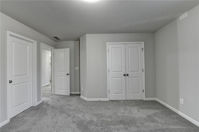 unfurnished bedroom with a closet and light colored carpet