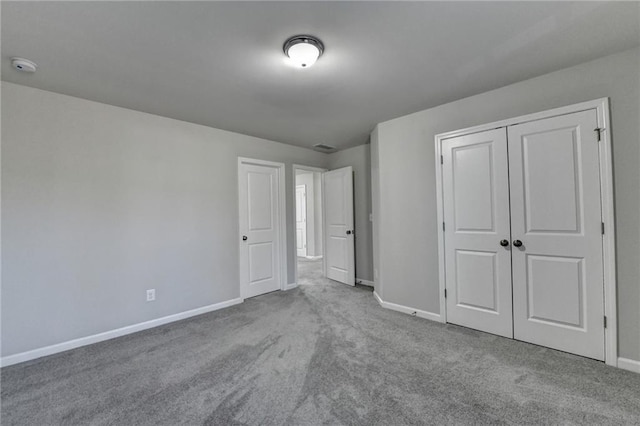 unfurnished bedroom featuring light colored carpet and a closet