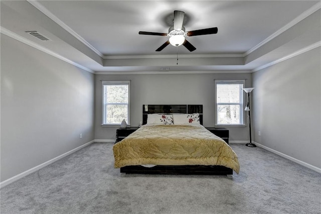 bedroom featuring multiple windows, carpet, a tray ceiling, and ceiling fan