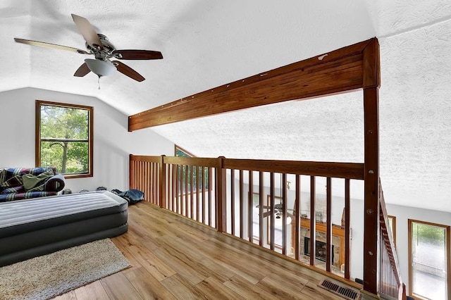 2775 Whippoorwill Cir, Duluth, GA 30097 - bedroom featuring a textured ceiling, lofted ceiling, multiple windows, wood finished floors, and ceiling fan