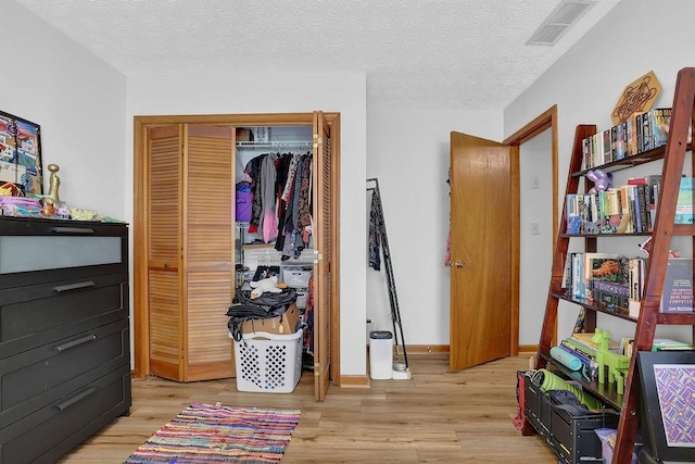 2775 Whippoorwill Cir, Duluth, GA 30097 - bedroom featuring light wood finished floors, a closet, and a textured ceiling