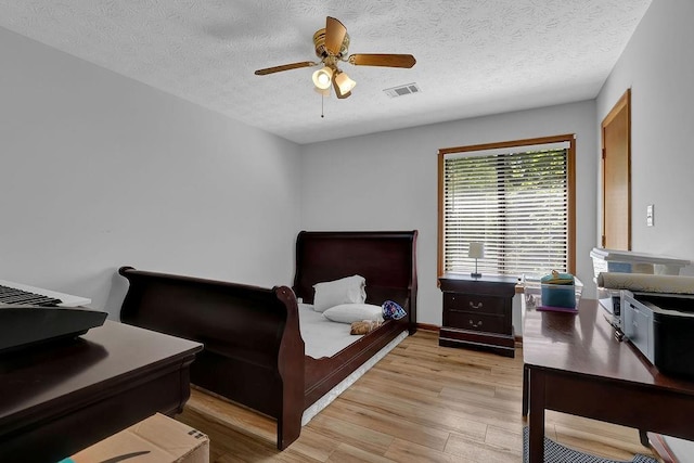 2775 Whippoorwill Cir, Duluth, GA 30097 - bedroom featuring light wood finished floors, a textured ceiling, and a ceiling fan