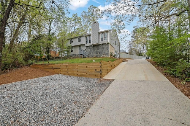 2775 Whippoorwill Cir, Duluth, GA 30097 - view of front facade featuring a chimney, driveway, and stone siding