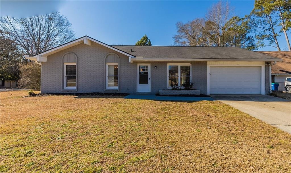 single story home featuring a front yard and a garage