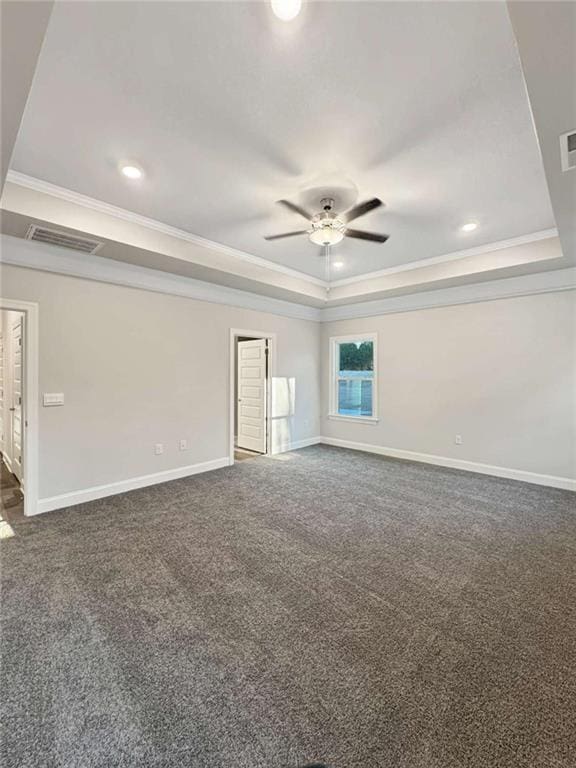 unfurnished room with visible vents, a tray ceiling, baseboards, and ornamental molding