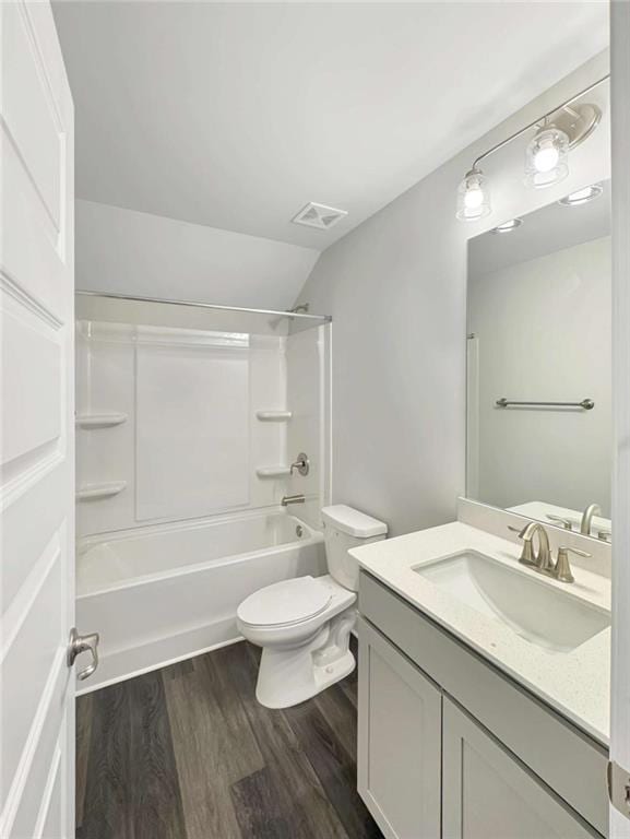 bathroom with toilet, wood finished floors, vanity, visible vents, and shower / washtub combination