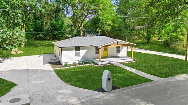 bungalow-style home with an outdoor structure, a front yard, central AC unit, a garage, and a porch