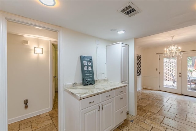 4101 Dunwoody Club Dr Unit 49, Atlanta, GA 30350 - kitchen with visible vents, stone tile floors, baseboards, light countertops, and a notable chandelier