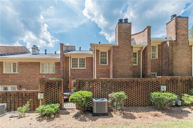 4101 Dunwoody Club Dr Unit 49, Atlanta, GA 30350 - rear view of property featuring brick siding, central air condition unit, and a chimney
