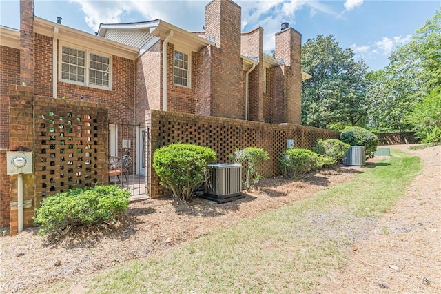 4101 Dunwoody Club Dr Unit 49, Atlanta, GA 30350 - view of side of property featuring central AC unit, a chimney, and brick siding
