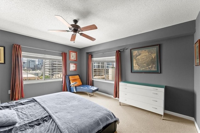 bedroom with light carpet, a textured ceiling, and ceiling fan