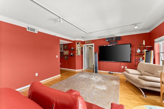 living room with track lighting, ornamental molding, hardwood / wood-style floors, and a textured ceiling