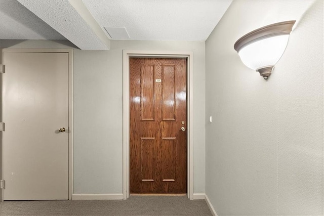 hallway featuring carpet and a textured ceiling