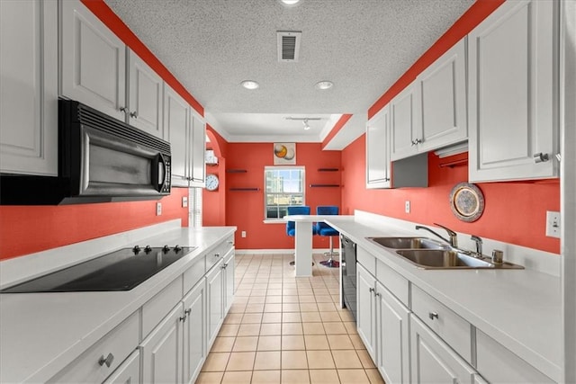 kitchen featuring sink, black appliances, and white cabinetry