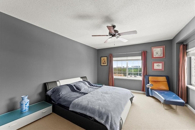 bedroom featuring a textured ceiling, ceiling fan, and carpet flooring