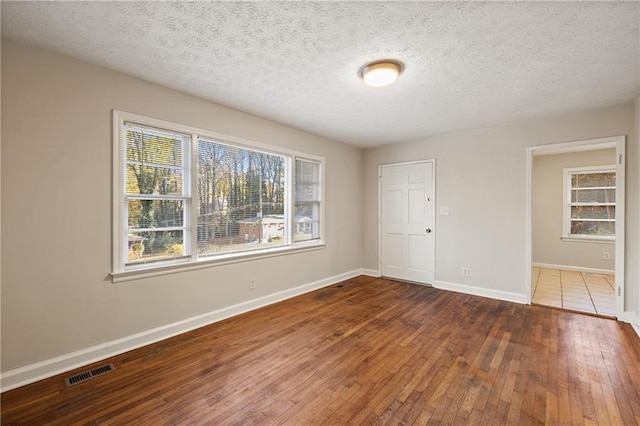 unfurnished bedroom with hardwood / wood-style flooring, a textured ceiling, and a closet