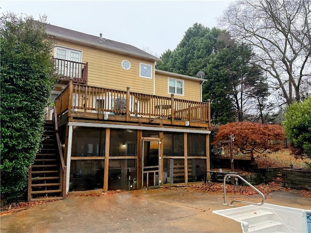 rear view of house featuring a sunroom and a patio